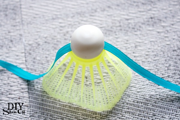 Close-up of badminton birdie garland with teal and white shuttlecocks