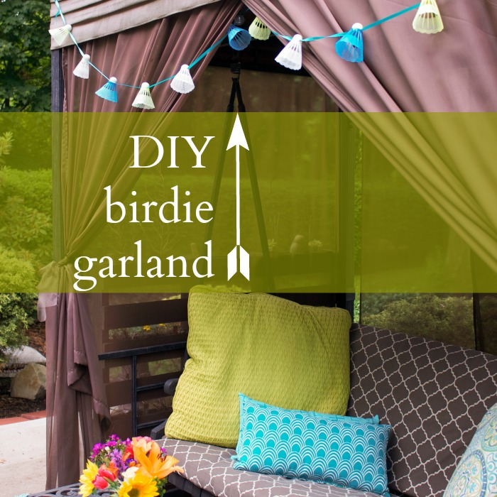 Birdie garland strung across back porch swing with sheer brown curtains