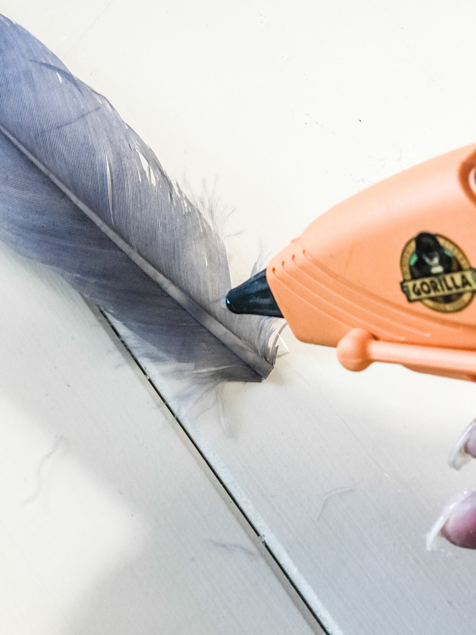 gray feather and glue gun