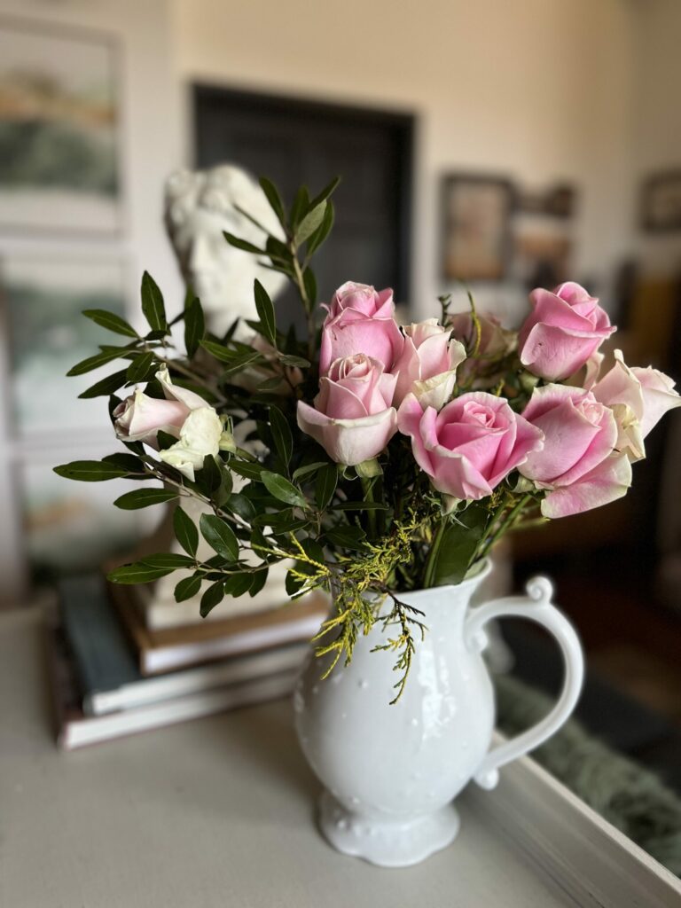 rose bouquet in white pitcher on styled table top 